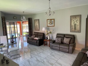 A spacious and very comfortable lounge with air con , large TV and dining area.