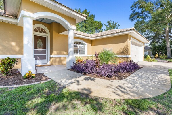 Freshly painted exterior from the front yard with views of planting beds