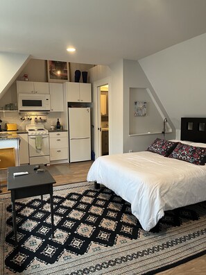 view of bed kitchen and bathroom entry