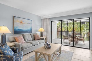 Large living room overlooking tropical gardens and pool area