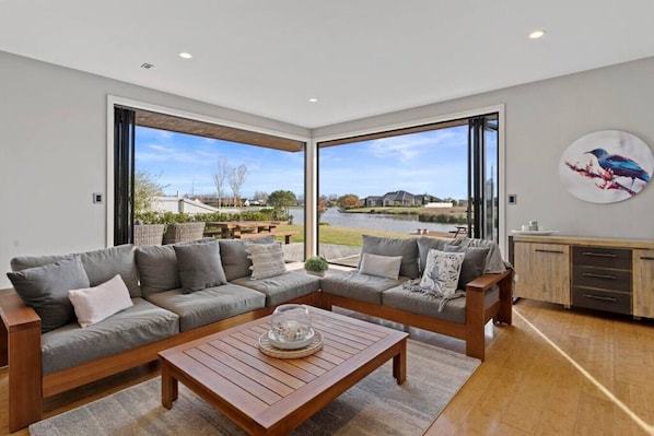 A welcoming lounge seamlessly connects to the outside space and down to the private jetty..