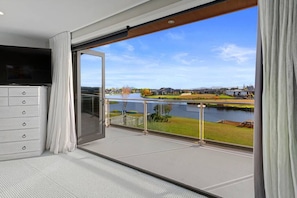 Enjoy canal views from the master bedroom's bifold doors, also revealing breathtaking views of the majestic Southern Alps on clear days