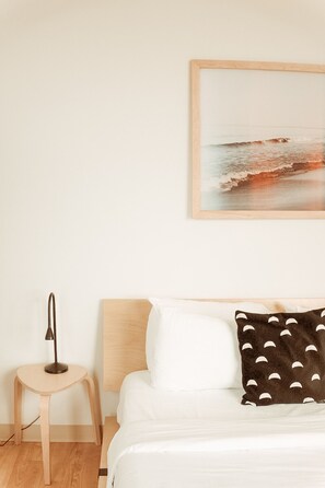 The bedroom alcove contains a queen bed with cotton sheets and both down and down alternative pillows