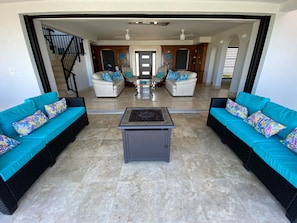 Pool deck firepit and sofas entering living room to front door