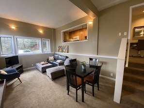 Spacious living room with TV, dining area and pull out queen bed.