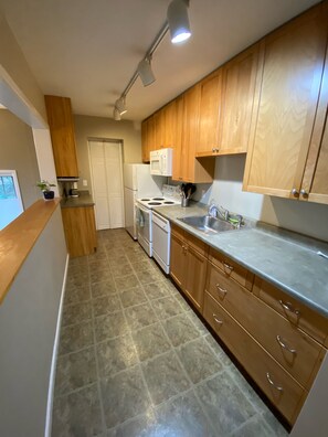 Kitchen with microwave, stove, dishwasher and fridge is well stocked.