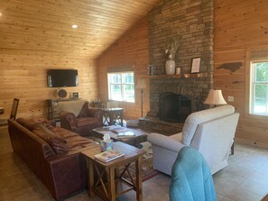 Wood burning fireplace, comfortable seating, and TV.