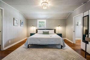 Large main bedroom with King bed, 55 inch TV, Closet, and a working desk.