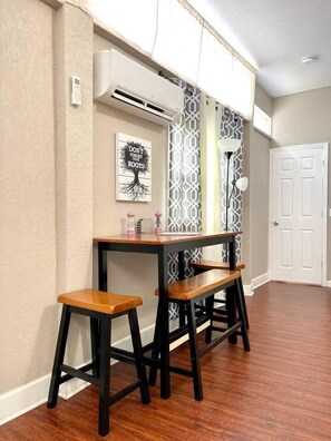 dining table, lamp, air conditioning, window with curtain, access door