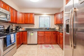 Kitchen, refrigerator, stove with oven, microwave, dishwasher, sink, knife set, coffee maker, window to the outside