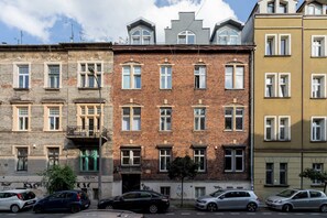 An exterior view of a historical building with classic architecture, surrounded by parked cars.
