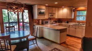 Treetop Lodge features a bright full kitchen, dining area, & large balcony deck.