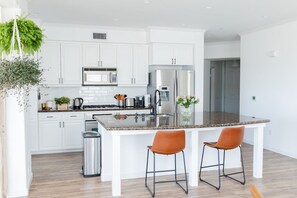 Stylish kitchen with marble island, seating for 4, and stainless appliances.