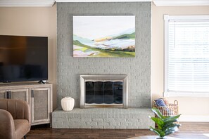 Decorative brick fireplace with large Smart TV.