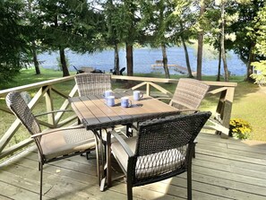 Large deck off living area with table for 4 and other patio furniture