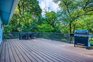 Spacious deck with serene wooded views, outdoor dining, and a grill — perfect for relaxing or entertaining!
