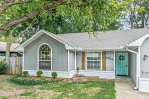 Discover the charm of this inviting white house with a green door, perfectly nestled in a serene setting.