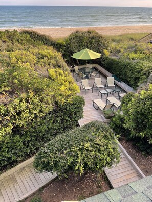 Private Open Deck between House and Beach with lounge chairs and dining table.