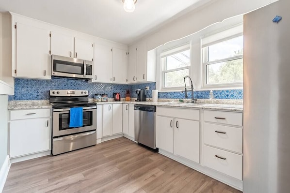 Kitchen is large with brand new Kenmore Stainless Steel Appliances. Kitchen is fully stocked with almost everything you need to cook (pots, pans, dishes, knives, mixers and more).
