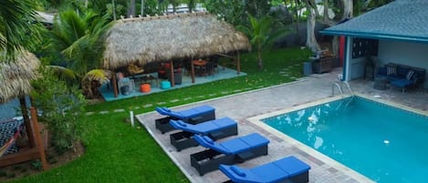 The pool, lounge chair and cabana with outdoor seating and more