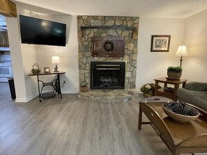 Living room has beautiful hearth and fireplace with gas logs