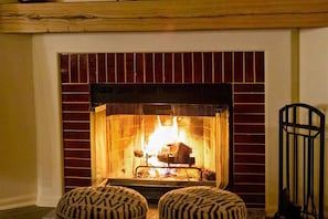 Get cozy around the fire in the wood burning fire place with the poufs.