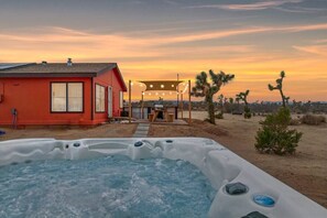 Hot tub under the open sky looking back at the outdoor dining area. 
