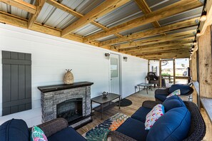 Secondary porch with outdoor electric fireplace for cozy evenings