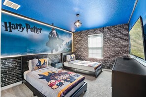 Harry Potter themed bedroom with two twin beds and smart tv.