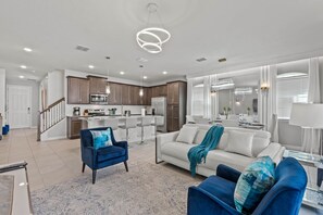 Colorful professionally decorated living room with rug and white leather couch.