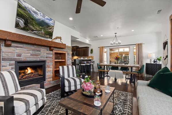 Living room with sofa, arm chairs, gas fireplace, and smart TV