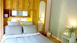 Chambre 1 avec un lit double, donnant sur une petite terrasse arrière