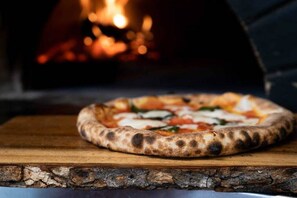 Create your own delicious wood-fired pizza using the outside pizza oven
