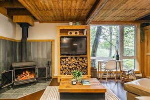 Salon avec foyer au bois et télévision 
