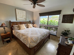 Master bedroom with beautiful carved wood bed and built in drawers.