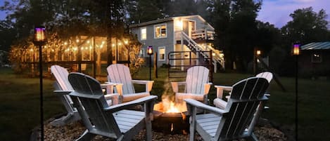 Fire pit w/custom built polywood Adirondack chairs, solar tiki torches, grapevine arbor + Moonflower Cottage behind it