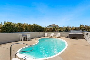 In the backyard, a fenced-in area features a large curved Private Pool for taking a dip after a long day on the beach.