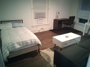Living room with desk, sofa bed and a twin bed