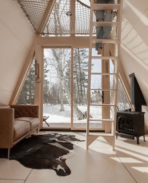 Cozy retreat in every season. Snowy light entering the cabin living room.