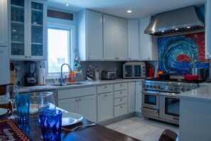 The kitchen is fully stocked with pots, pans, mixer, food processor, shopper, cutting boards, and gear to making cooking and baking easy for your crew.