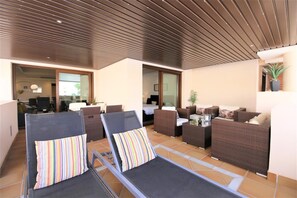 View of the spacious balcony with seating and dining area plus two sunloungers