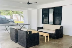 Covered front patio with a ceiling fan and ping pong table.