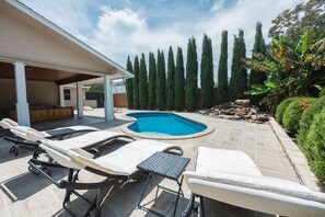 Gorgeous outdoor pool with pool chairs and relaxing patio space