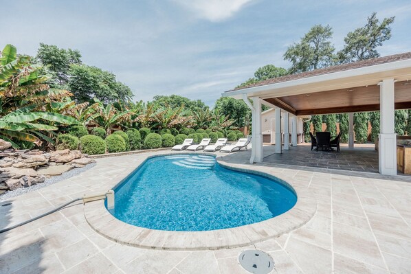 Gorgeous outdoor pool with pool chairs and relaxing patio space