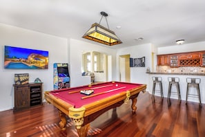 Enjoy the fun game room with pool table, arcade game, and a wet bar.