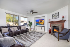 Spacious living room with fireplace and huge TV.