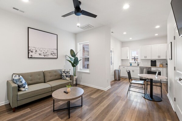 Relax in this bright, open-concept space featuring a cozy living area, sleek kitchen, and chic dining setup—ideal for work or leisure!