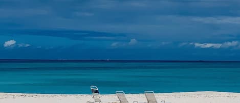 Treasure Cay Beach at peak time featuring relaxing lawn chairs.