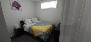 First bedroom with Queen size mattress, dresser, and mirror