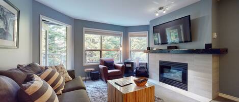 Living room with large windows looking out to the forest